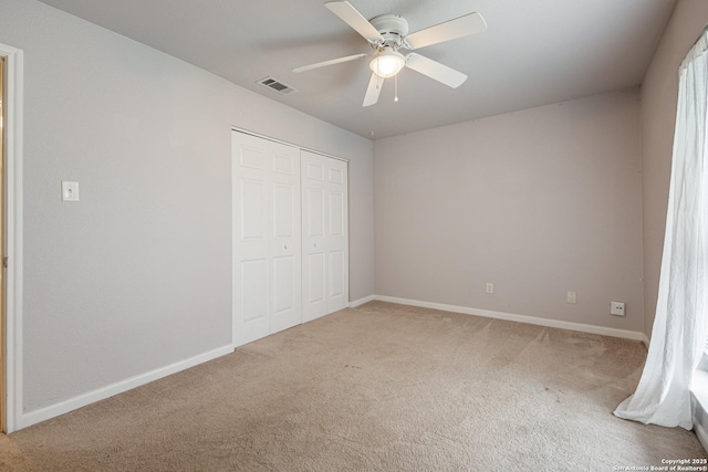 unfurnished bedroom with a closet, carpet, visible vents, and baseboards