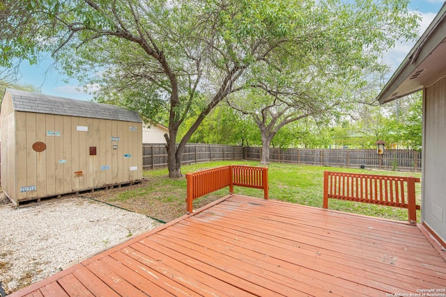 wooden terrace with a storage shed, a lawn, an outbuilding, and a fenced backyard