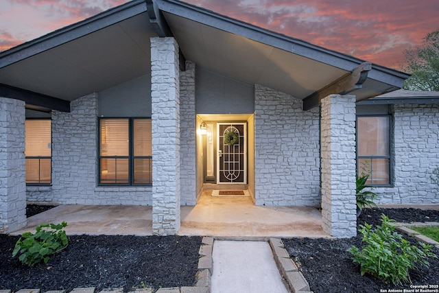 exterior entry at dusk with stone siding