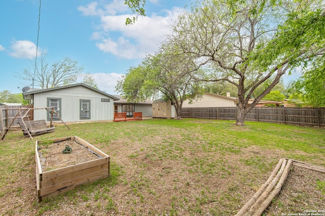 view of yard featuring a wooden deck, a fenced backyard, and a garden