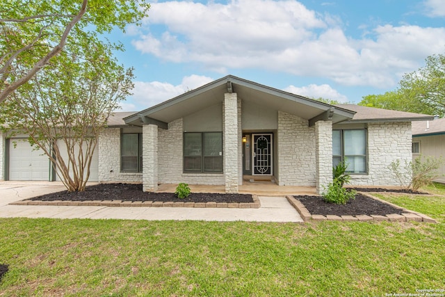 mid-century modern home featuring a garage, driveway, stone siding, and a front lawn
