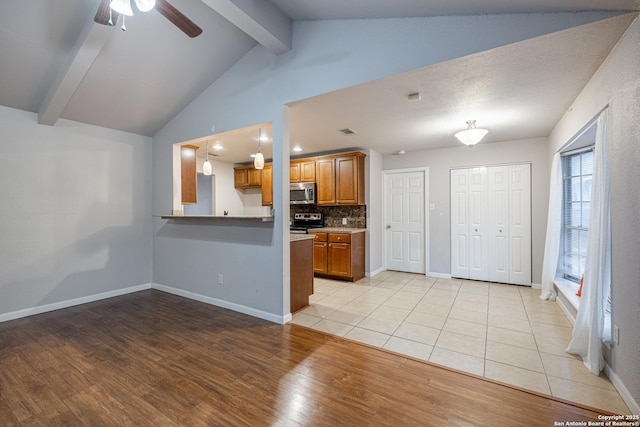 kitchen with tasteful backsplash, brown cabinetry, lofted ceiling with beams, light wood-type flooring, and stainless steel appliances