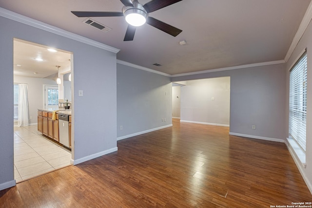unfurnished room with light wood finished floors, baseboards, visible vents, ceiling fan, and ornamental molding