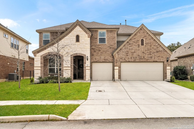 view of front of home with brick siding, a shingled roof, central AC unit, concrete driveway, and a front yard