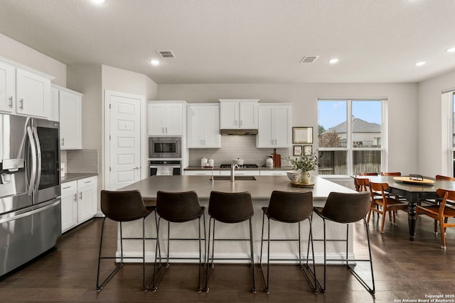 kitchen featuring visible vents, appliances with stainless steel finishes, backsplash, and a sink