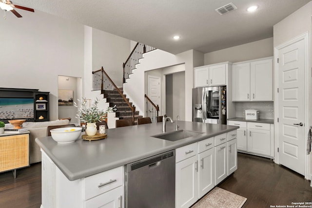 kitchen with dark wood-style floors, stainless steel appliances, visible vents, open floor plan, and a sink