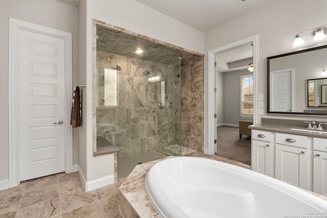 bathroom with a garden tub, baseboards, tiled shower, and vanity