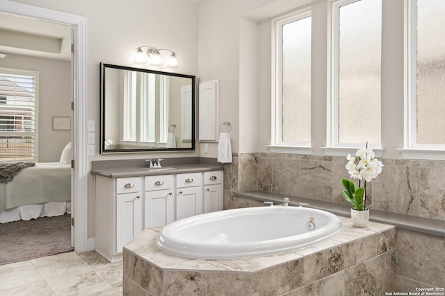 ensuite bathroom with a garden tub, vanity, and ensuite bath