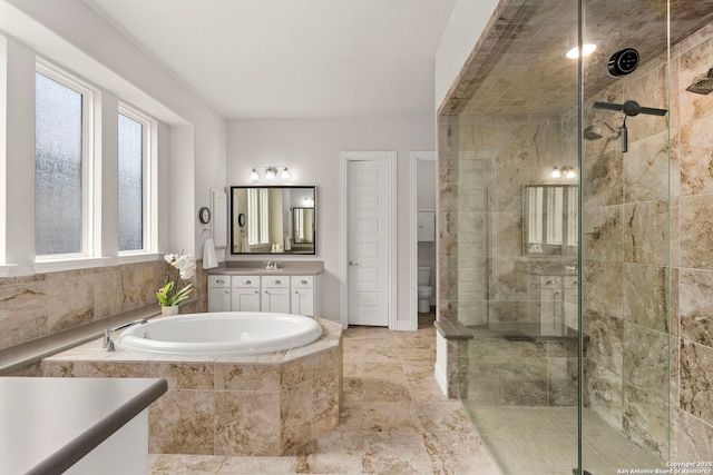 bathroom featuring a stall shower, vanity, and a bath