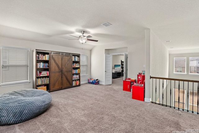 sitting room featuring baseboards, visible vents, ceiling fan, carpet, and a textured ceiling