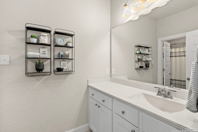 full bath with baseboards and vanity