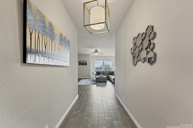 corridor with baseboards and wood finished floors