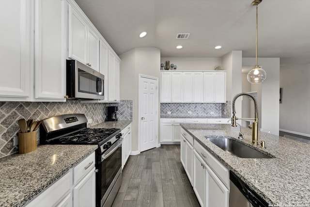 kitchen with stainless steel appliances, a sink, visible vents, and white cabinets