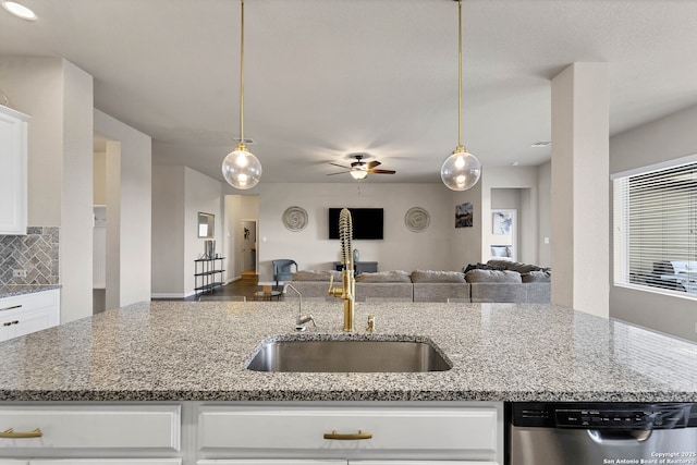 kitchen featuring a sink, light stone countertops, white cabinets, and stainless steel dishwasher