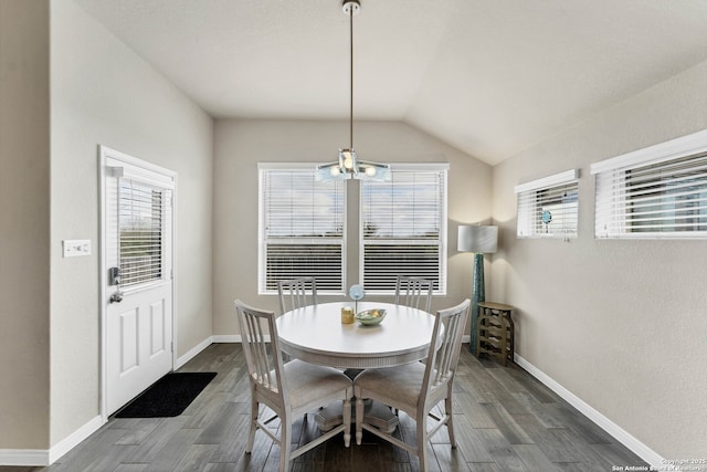 dining room with lofted ceiling, baseboards, a chandelier, and dark wood-type flooring