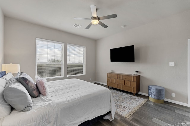 bedroom featuring ceiling fan, wood finished floors, visible vents, and baseboards