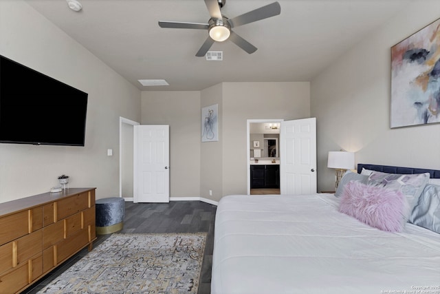 bedroom featuring ceiling fan, visible vents, baseboards, dark wood-style floors, and ensuite bath