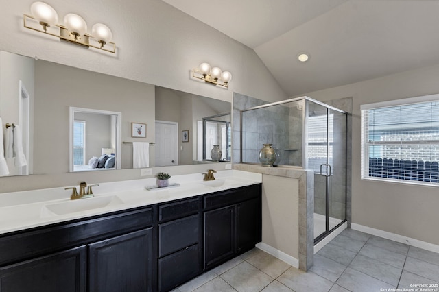 ensuite bathroom featuring lofted ceiling, tile patterned floors, a sink, and ensuite bathroom