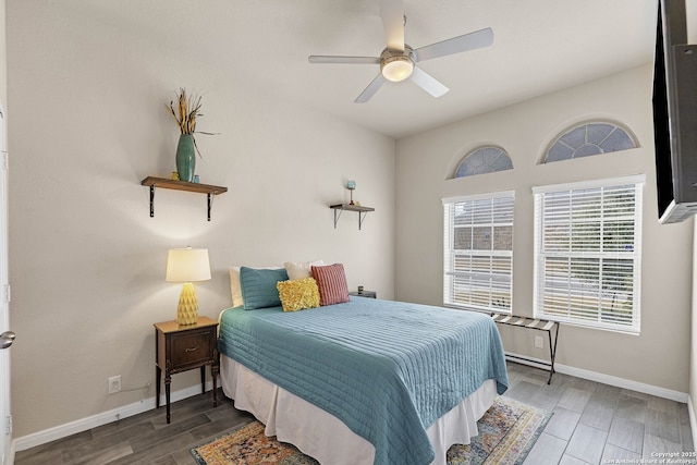 bedroom featuring a ceiling fan, dark wood-style flooring, and baseboards