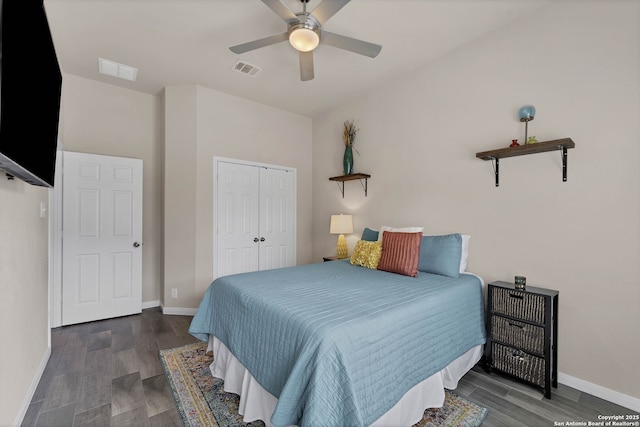 bedroom with baseboards, visible vents, ceiling fan, dark wood-type flooring, and a closet