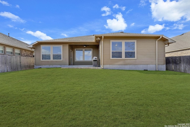 back of house with a lawn and a fenced backyard