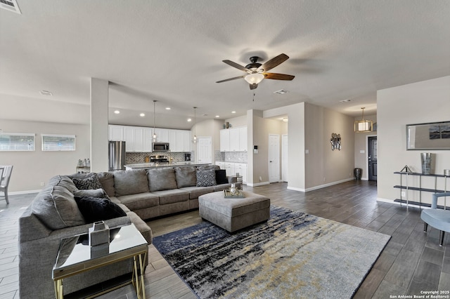 living area featuring dark wood-style floors, visible vents, ceiling fan, and baseboards