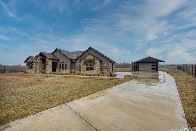 view of front of home featuring a garage, a front yard, fence, and an outbuilding