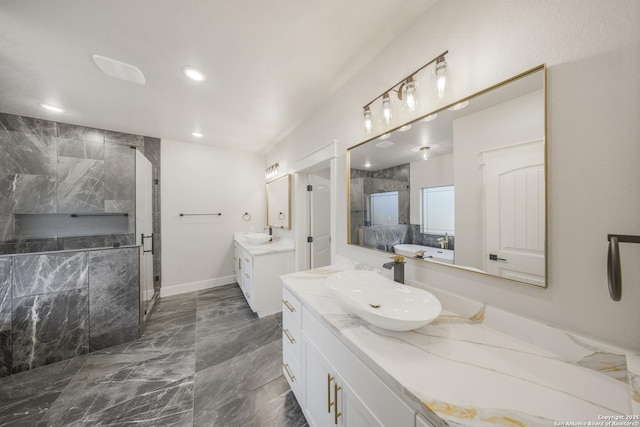 bathroom featuring recessed lighting, two vanities, a sink, marble finish floor, and a stall shower