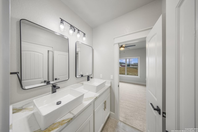 full bathroom with a ceiling fan, a sink, baseboards, and double vanity