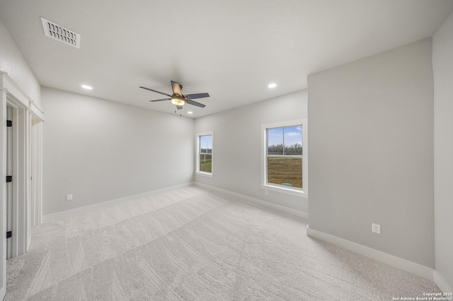 unfurnished room with recessed lighting, light colored carpet, a ceiling fan, visible vents, and baseboards