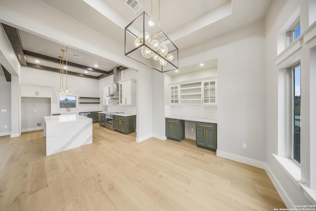 kitchen featuring stainless steel stove, a kitchen island, white cabinetry, decorative light fixtures, and green cabinetry