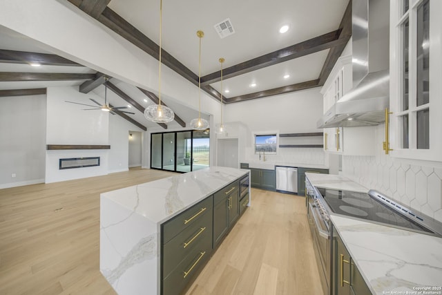 kitchen with visible vents, white cabinetry, wall chimney range hood, light stone countertops, and pendant lighting