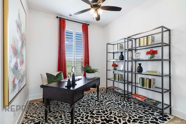 office area featuring visible vents, baseboards, a ceiling fan, and wood finished floors