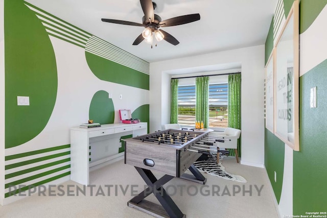 game room with baseboards, a ceiling fan, and light colored carpet