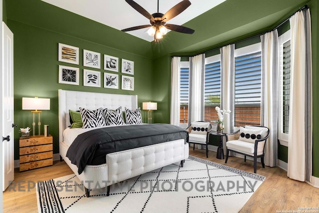 bedroom with ceiling fan, wood finished floors, and baseboards