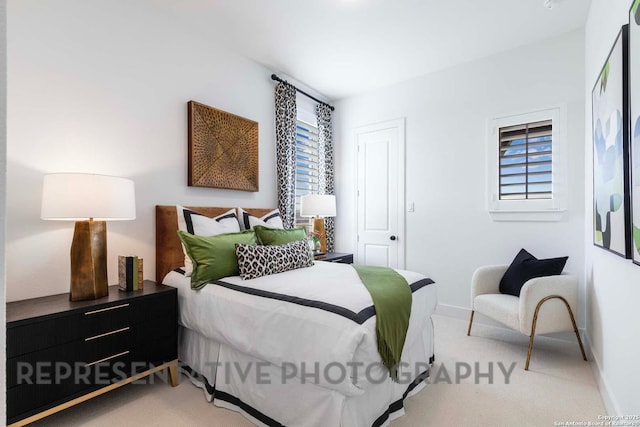 bedroom with baseboards and light colored carpet