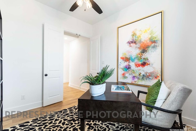 office featuring wood finished floors, a ceiling fan, and baseboards