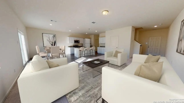 living area featuring recessed lighting, visible vents, and baseboards