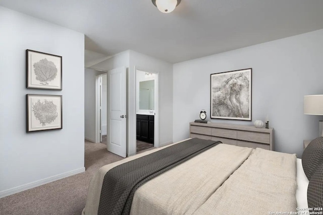 bedroom with light colored carpet, ensuite bath, and baseboards