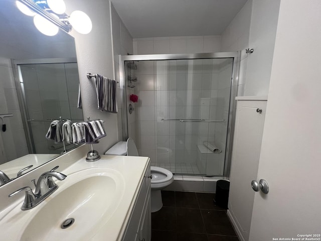 bathroom with toilet, tile patterned floors, a stall shower, and vanity