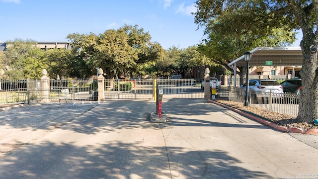 view of road featuring a gate, curbs, and a gated entry