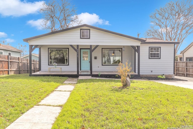 bungalow with covered porch, fence, and a front lawn