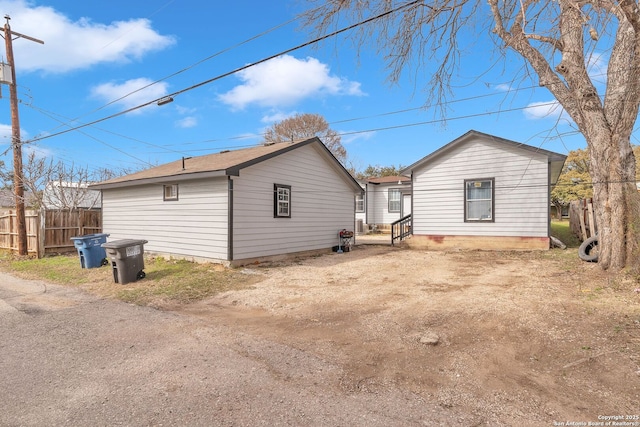 view of side of property featuring fence and driveway