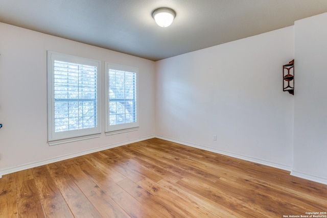 unfurnished room featuring baseboards and wood finished floors