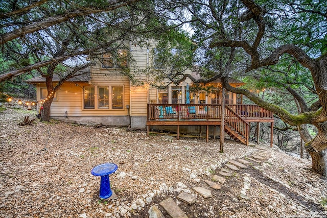 rear view of house featuring stairs and a deck