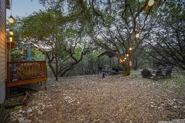 view of yard with an outdoor fire pit and a deck