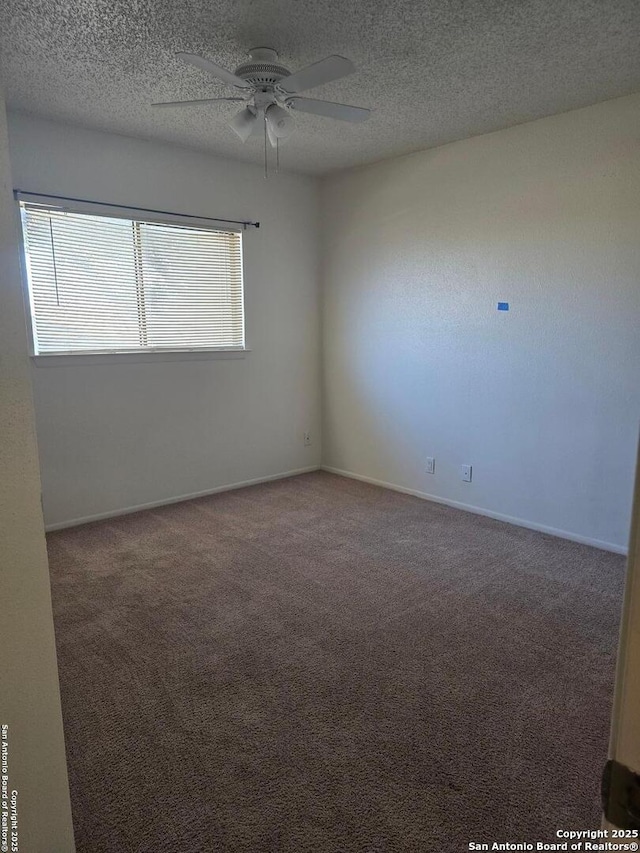 carpeted empty room featuring ceiling fan, a textured ceiling, and baseboards