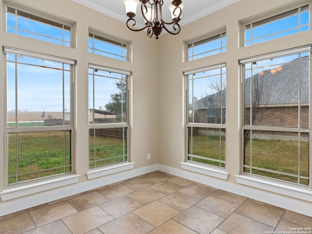interior space with baseboards, ornamental molding, a wealth of natural light, and an inviting chandelier