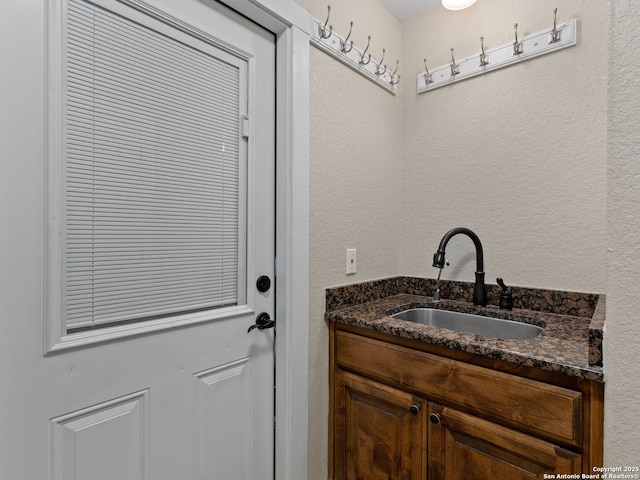 bathroom featuring a sink and a textured wall