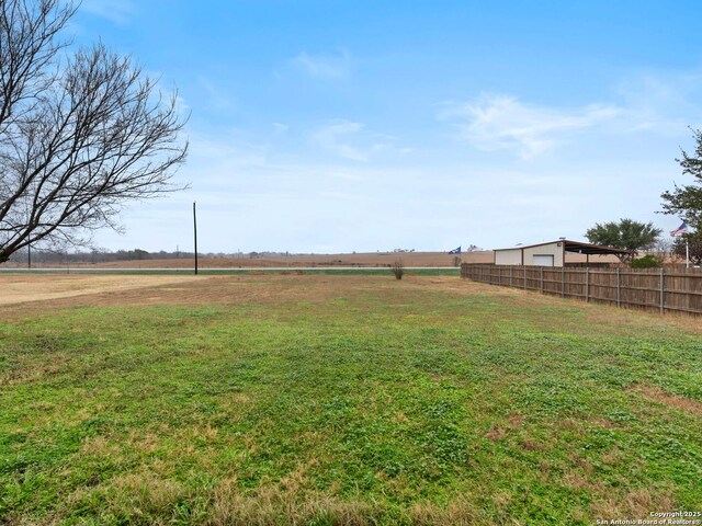 view of yard featuring a rural view and fence